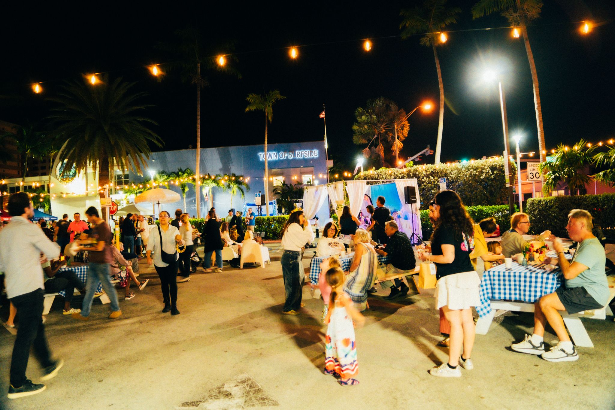 A Surfside street filled with people under string lights during the Third Thursday series